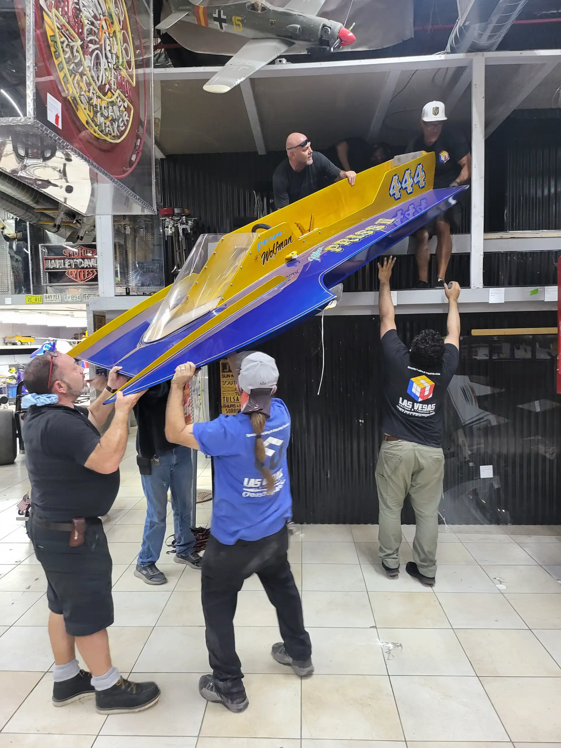 Staff installing a sculptural relief artwork on a wall